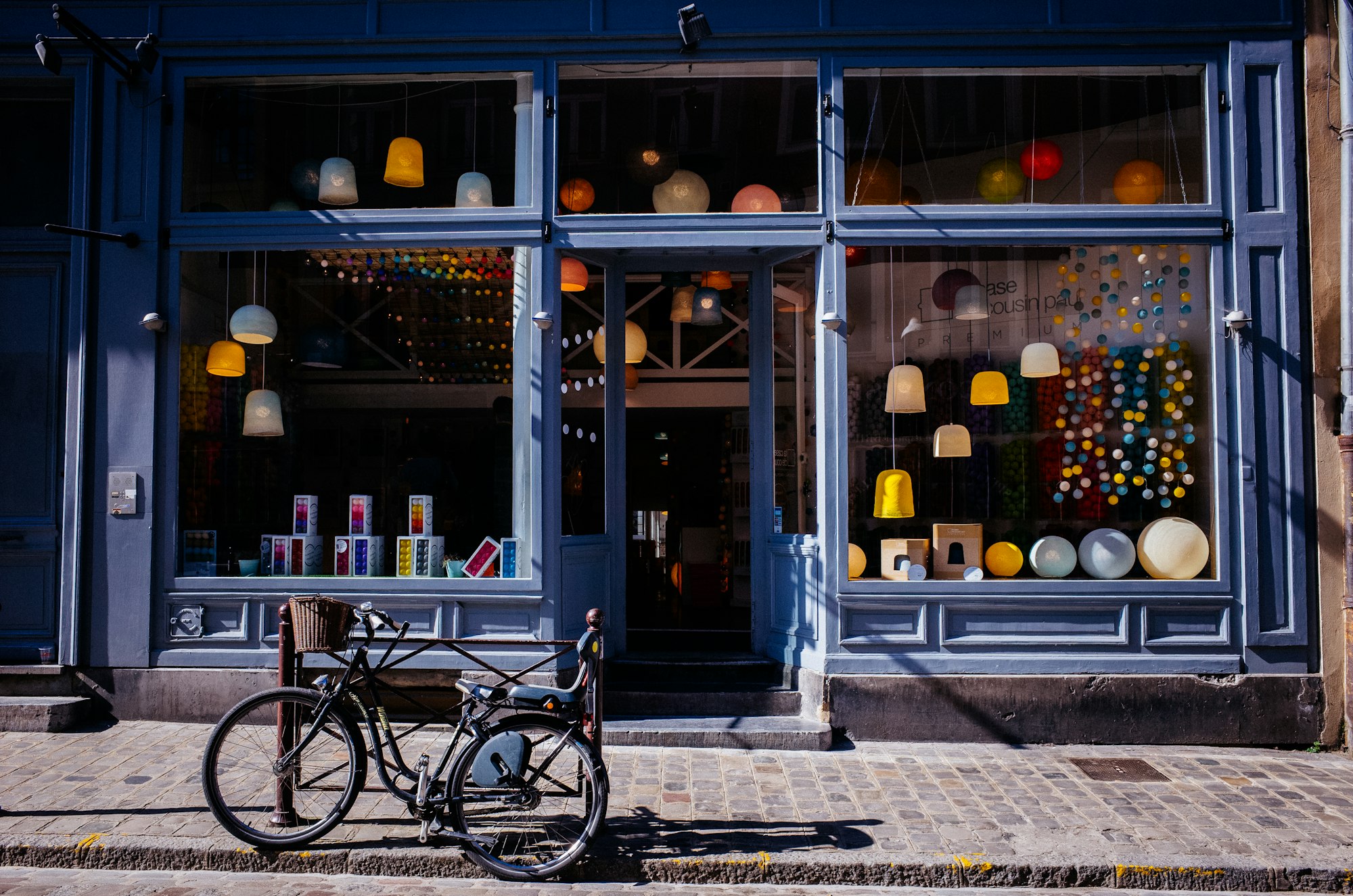 Escaparate de un comercio local, con bicicleta aparcada en el adoquín
